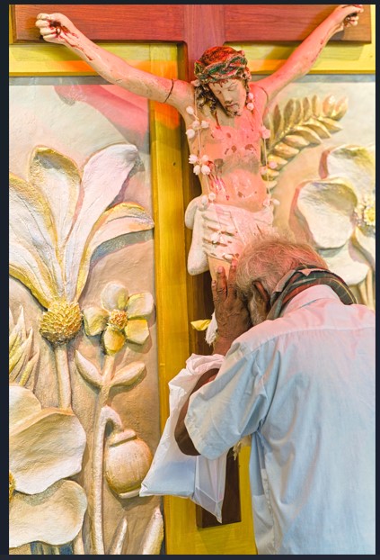 Devotee praying at the crucifix
